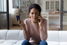 Worried young woman call bank unable pay by card