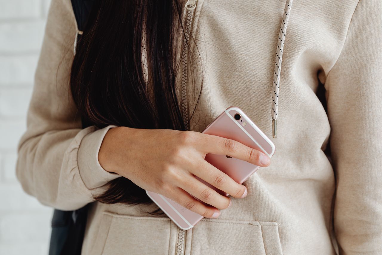 Girl holding a light pink phone