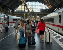 Passengers with suitcases in train station