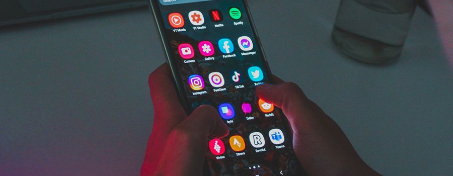 Person holding a smartphone with apps