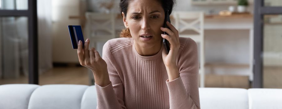 Payment fraud, lady holding a credit card on the phone